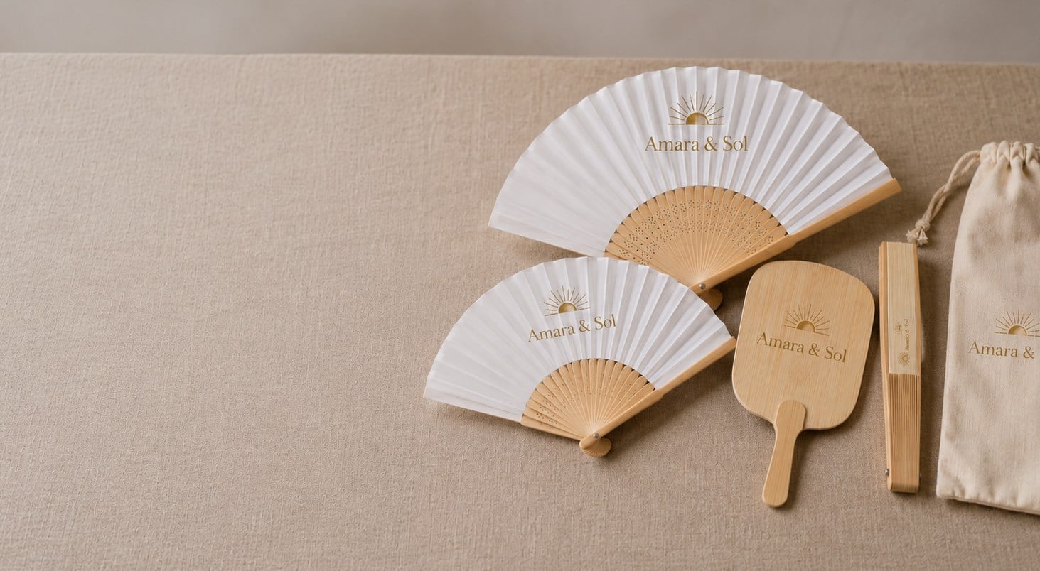 Custom bamboo hand fans with printed design spread on a linen table